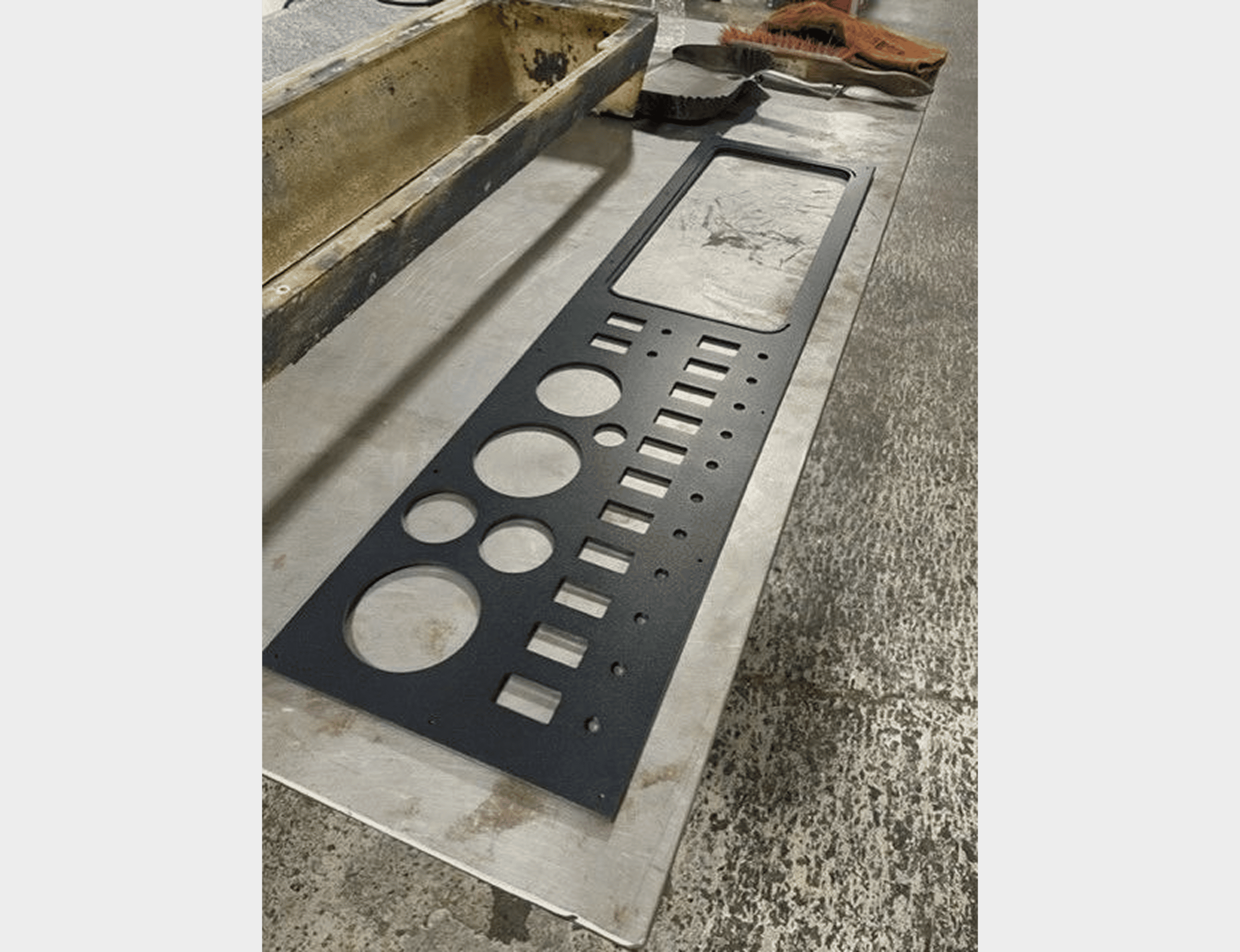 Metal panel with various cut-out shapes.