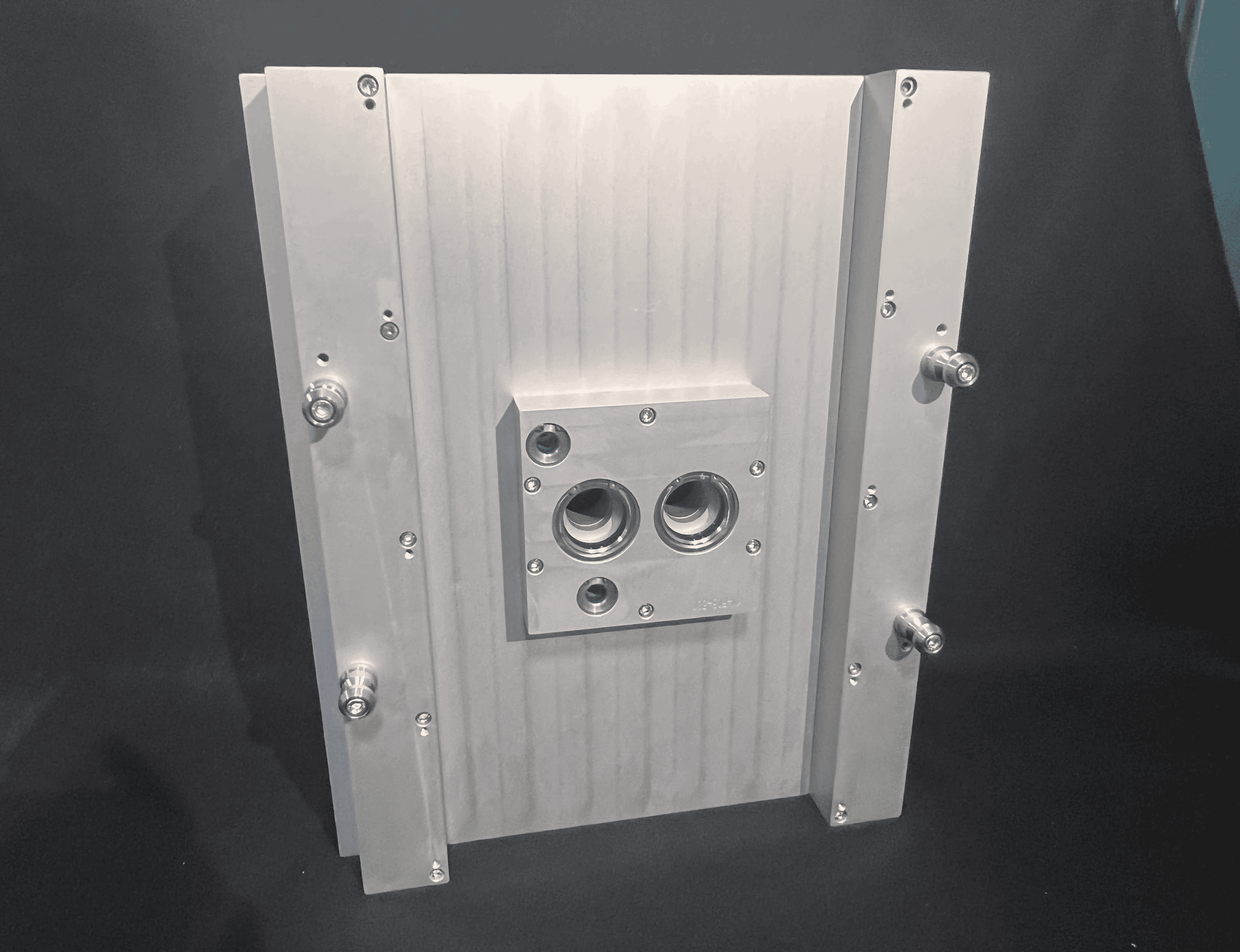 Metallic industrial component with screws and bolts.